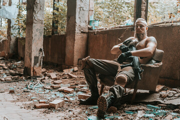 a male military soldier in an abandoned building with a gun poses, shoots and takes aim