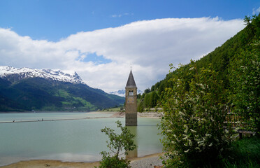 a picturesque view of lake Resia and the sunken church steeple of Lago di Resia in the Curon region...