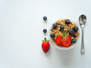 Naklejka na ściany i meble High Res Healthy diet breakfast with homemade granola muesli and fresh strawberries, blueberries on a white background. The concept of health and beauty. Copy Space for information, top view, Flat Lay