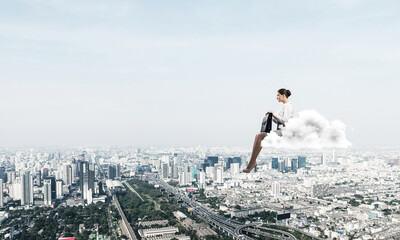 Businesswoman or accountant on cloud floating high above modern city