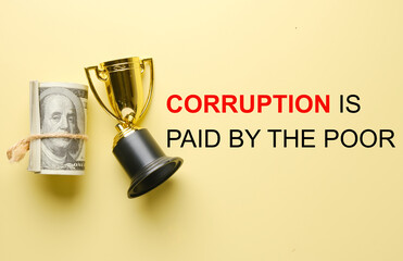 A picture of fake money and broken trophy with the word "Corruption is paid by the poor".