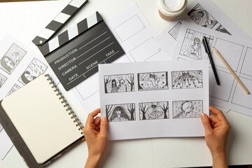 Storyboard in the hands of the artist. Drawn characters for a movie or cartoon on the desktop. - 488010028