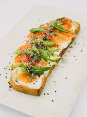 Tostada de salmaon ahumado, queso fresco, aguacate y rucula