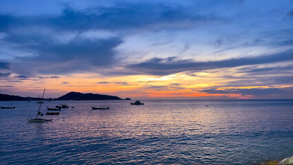 Naklejka na ściany i meble Long tail Boat on colourful sunset over Patong Beach Phuket Thailand