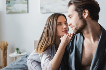 young woman looking at bearded man in robe.