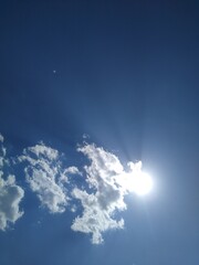 the sun is behind a small dot in the blue sky. High quality photo