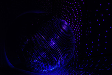 Fototapeta premium Rays of bright blue and purple light on the floor and walls. Disco ball reflecting light in a dark hall for discos. Dark photo. Copy space.