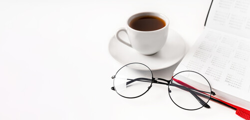 A modern office desk with a notepad, glasses and a coffee or tea cup on a white background with a place for text