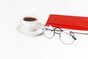 A modern office desk with a notepad, glasses and a coffee or tea cup on a white background with a place for text