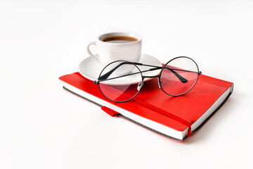 A modern office desk with a notepad, glasses and a coffee or tea cup on a white background with a place for text