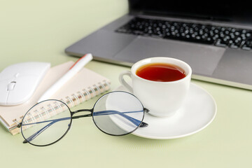 Simple Trendy Office Desk with laptop, tea mug and office elements. Home Office Desktop