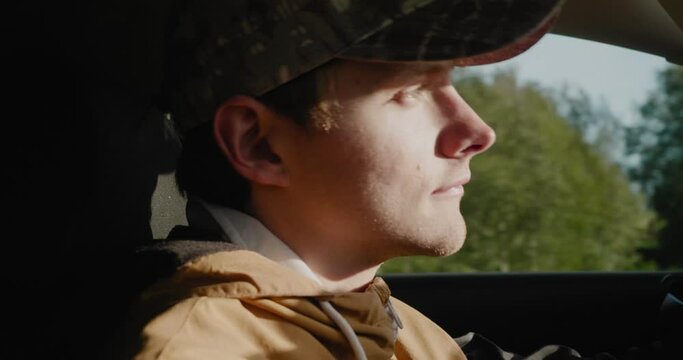 Young Scandinavian Man Drives His Car Towards The Sunlight and has Trouble Seeing, Autumn Late Day - Handheld Close Up