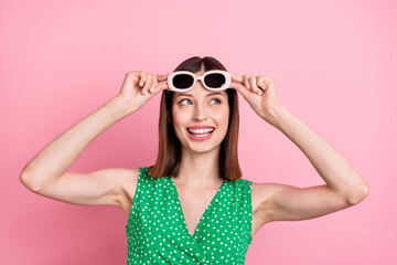 Photo of youth cheerful lady curious look empty space eyewear dream isolated over pink color background