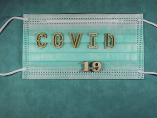 The word covid variant omicron in wooden letters on the face mask. High quality photo