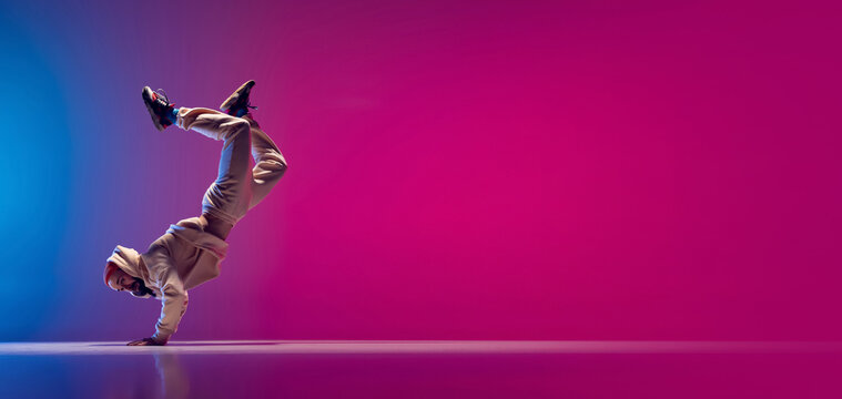 Flyer with young flexible sportive man dancing breakdance in white outfit on gradient pink blue background. Concept of action, art, beauty, sport, youth
