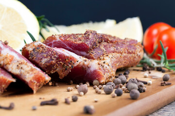 dried and spiced meat sliced on a wooden board