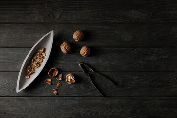 geschälte Walnüsse in einer Schale mit Nussknacker auf Holzbrett