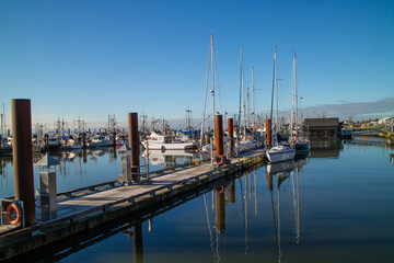 Fototapeta na wymiar Pier, porto ou atracadouro de barcos de pesca e veleiros, com casas e bares ao redor do porto
