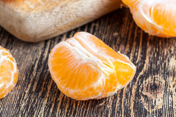 peeled ripe juicy tangerine on a wooden table