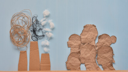 the concept of environmental pollution by factories made composition of paper and thread, people and chimneys of a factory with smoke on a blue background