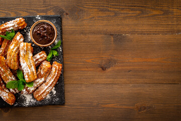 Fried churros with chocolate sauce and mint. Spanish sweets for breakfast