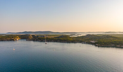 Aerial drone view of sunset over Kornati islands near the Sibenik city, Croatia. Water bay with boats ans soft sun light.