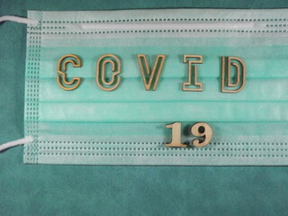 The word covid variant omicron in wooden letters on the face mask. High quality photo