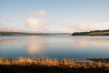 Kielder England: 11th January 2022: Warm sun shining on Kielder Reservoir on Lakeside Way. Stunning dramatic colours