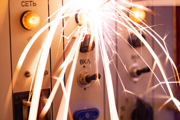Electronic sparks scatter quickly and sharply from a short circuit on technological equipment in...