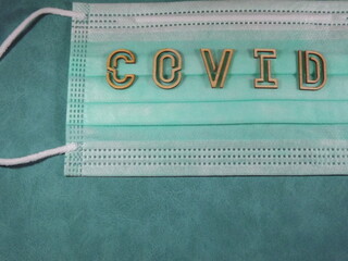 The word covid variant omicron in wooden letters on the face mask. High quality photo