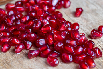 scattered pomegranate seeds on a wooden board