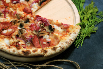 Big pizza without one piece on a dark background