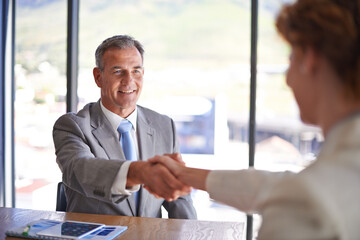 Pleasure doing business with you. Shot of a businessman shaking the hand of a colleague in the boardroom.