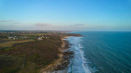 Aerial view at afternoon of small Breton village on stony beach. Blue Atlantic water and cloudy sky for copy space. Drone point of view. France, Brittany, Mesperleuc. France, Brittany, Mesperleuc.