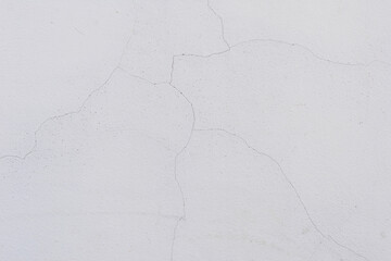 White cracked concrete wall surface on natural light.