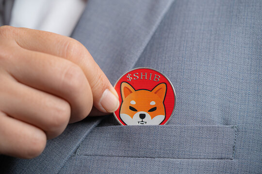 Focus select and blur Foreground Shiba coin SHIB included with Cryptocurrency hand picked in suit bag business man or bank employees wearing a gray suit. Filed and put and give to me.