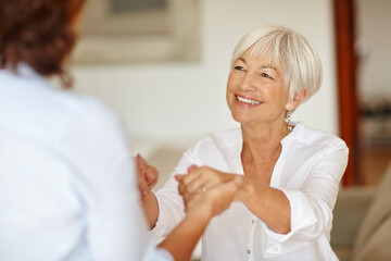 Enjoying a mother and daughter get-together. Shot of a senior woman holding her daughters hands.