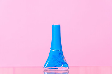 blue nail polish on a pink background