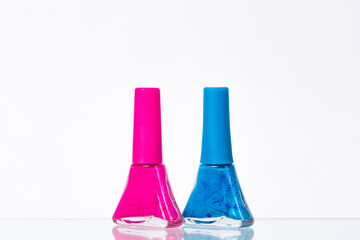 blue and pink nail polish on a white background