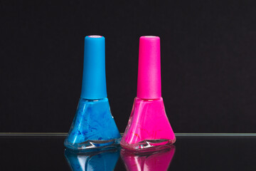 blue and pink nail polish on a black background