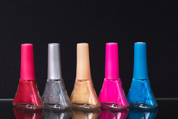 nail polish of different colors on a black background