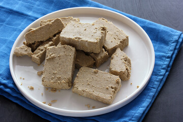 Halva cut into pieces on a white plate.