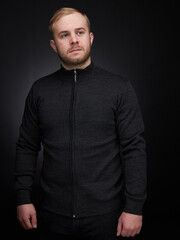 vertical portrait  blond man on a dark background, in a jacket