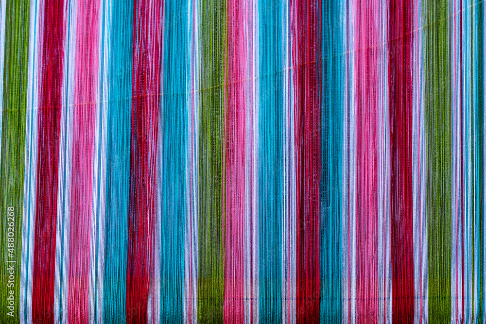 Wall mural A closeup image of colorful strands of traditional weaving by the Karen people of Myanmar