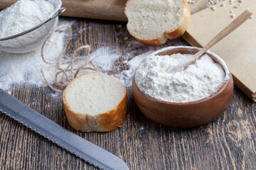 wheat baguette on the table with flour and various plant grains