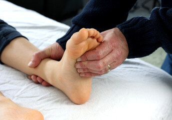 Close up hand of Podiatrist or an Orthopedic Foot and Ankle Specialist checking and give treatment...