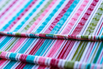 A closeup image of colorful strands of traditional weaving by the Karen people on a wooden loom