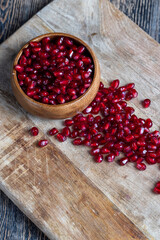scattered pomegranate seeds on a wooden board