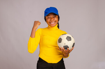 beautiful african lady smiling as she hold football