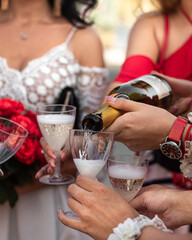 Girls in chevrons pour champagne into glasses on the bachelorette party
